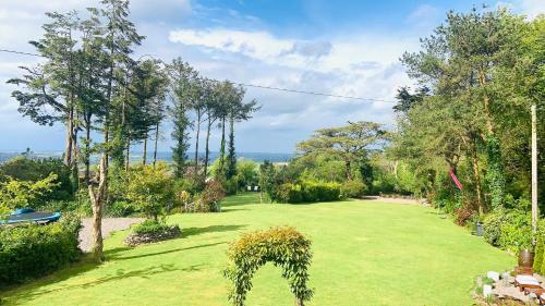 a garden with a green lawn with trees and bushes at Fortwilliam Farm T12DNN2 in Cork