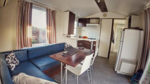 un soggiorno con divano blu e tavolo e una cucina di Triocamp Praha a Praga