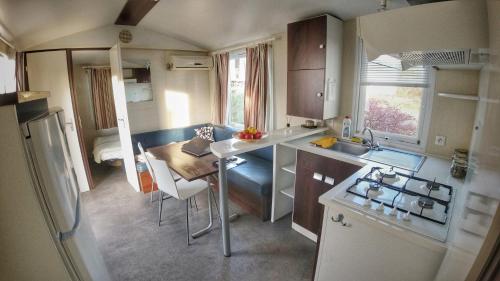 a small kitchen with a table and chairs in a caravan at Camping Prima in Týn nad Vltavou