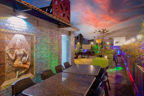 a restaurant with tables and a painting on the wall at Icon Regency by Bhagini in Bengaluru