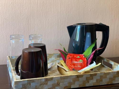 a coffee maker and two mugs on a counter at Ocean Lake Tourist Residence in Grand Baie