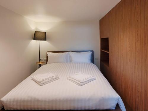 a bedroom with a bed with two books on it at Play Poshtel & Cafe' in Krabi town