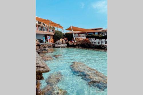 a pool at a resort with blue water at Appartement ezzouhour DAR SAMMOUD in Kelibia