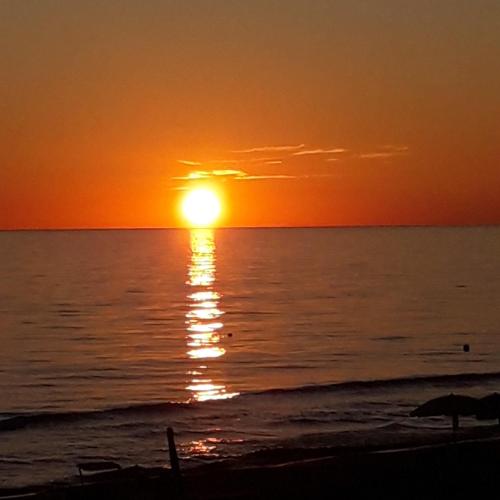 a sunset on the beach with the sun setting at B Palace in Ardea