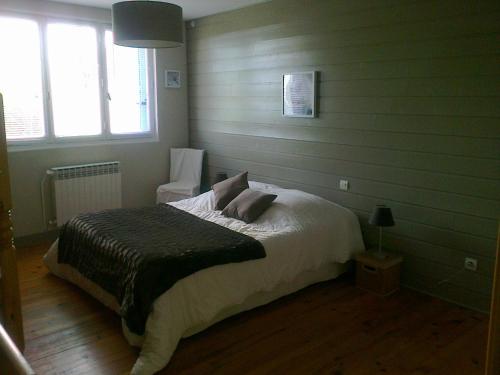 a bedroom with a bed with white sheets and pillows at Chambres d'hôtes vue panoramique proche de Carcassonne in Villardonnel