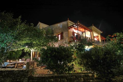 a house with a car parked in front of it at night at Koromilia Villa in Neo Klima