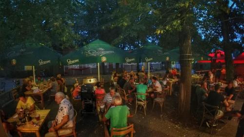 un gruppo di persone seduti ai tavoli in un ristorante all'aperto di Camping Sokol Praha a Praga