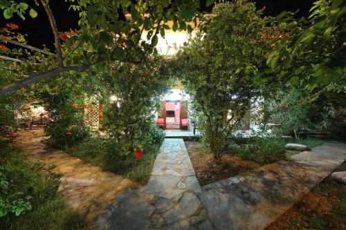 a garden with a pathway leading to a house at Koromilia Villa in Neo Klima