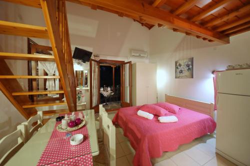 a bedroom with a pink bed and a table at Koromilia Villa in Neo Klima