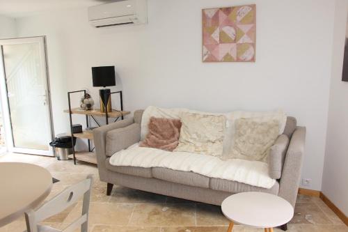 a living room with a couch and a table at Appartement PERIGUEUX Garage attenant Fibre Climatisation in Périgueux