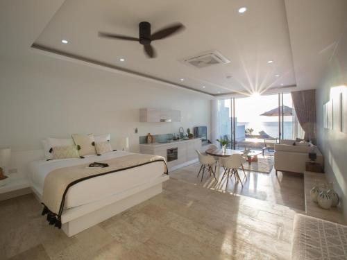 a bedroom with a bed and a kitchen and a living room at Skye Beach Hotel - Koh Samui in Choeng Mon Beach