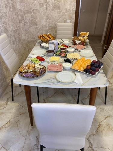 a table with food on it with two white chairs at Hotel Sharl in Ninotsminda
