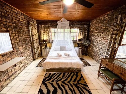 a bedroom with a bed in a brick wall at Masasana’s Rest in Hazyview