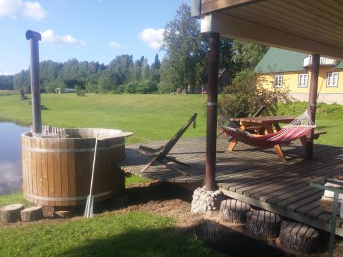 a wooden deck with a hammock and a picnic table at Aratsaare Holiday home in Kõpu