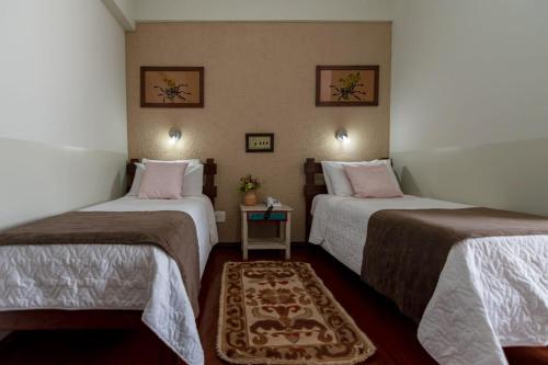 a room with two beds and a table in it at Diamante Palace Hotel in Diamantina