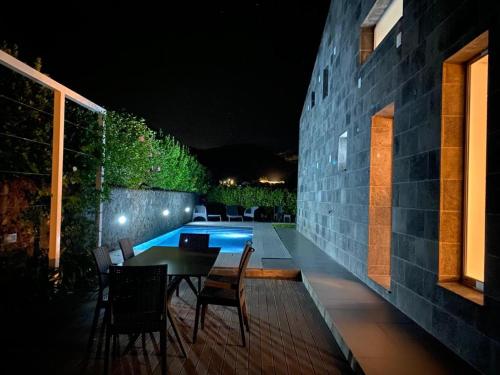 a patio with a table and chairs next to a pool at H. S. Caloura in Lagoa