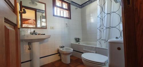 a bathroom with a toilet and a sink and a tub at Casa rural Los Dragos in Fuencaliente de la Palma