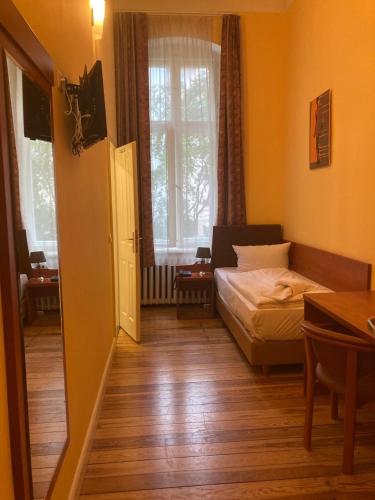 a small bedroom with a bed and a window at City Hotel am Kurfürstendamm in Berlin