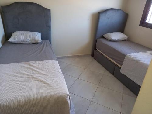 a room with two beds and a tiled floor at Oceanica by Smir Park luxury apartment Marina Smir in M'diq
