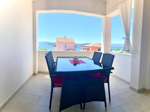 a dining room with a table and a large window at Apartment Lucie 4 in Biograd na Moru