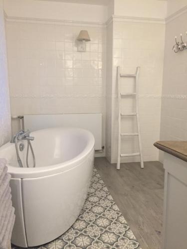 a white bathroom with a white tub and a ladder at Villa La Croisée des Chemins in Bray-Dunes