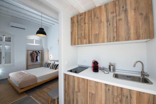 una cocina con fregadero y una cama en una habitación en Avli Suites en Mykonos