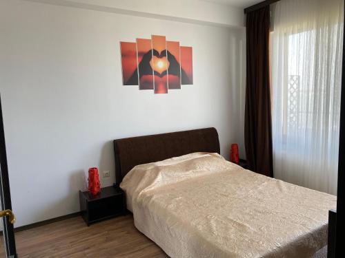 ママイアにあるDUMAR Apartamentのベッドルーム1室(ベッド1台付)が備わります。壁には絵画が飾られています。