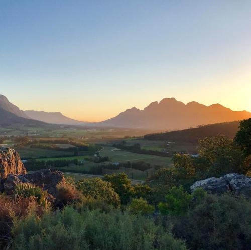 a view of a valley at sunset with mountains at 7 Koppies in Franschhoek
