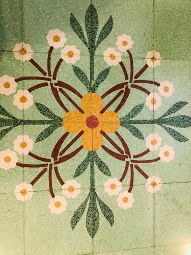 a tile with a flower design on the floor at Sicilia Vacation rooms in Trapani