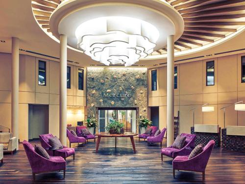 a lobby with purple chairs and a table at Mercure Iguazu Hotel Iru in Puerto Iguazú