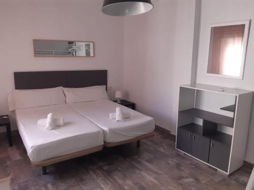 a bedroom with a bed with two white towels on it at Apartamento Catedral Centro in Granada
