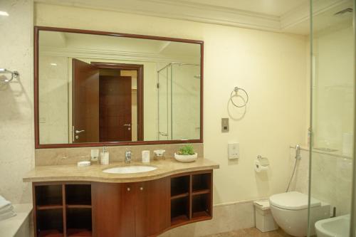 a bathroom with a sink and a toilet and a mirror at Apartment in Dubai