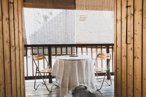 a table and chairs in a room with a window at Le Triplex Carnot - Apartment with air conditioning for 5 people in Annecy