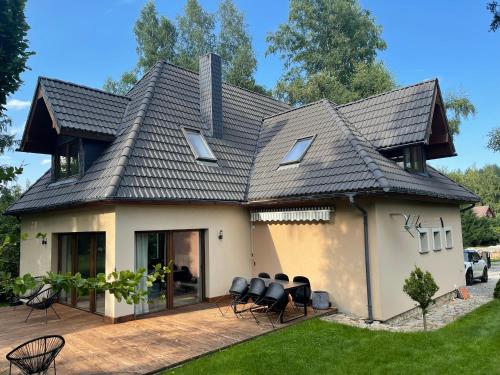 a house with a roof that has black chairs at Trzy Jawory in Piechowice