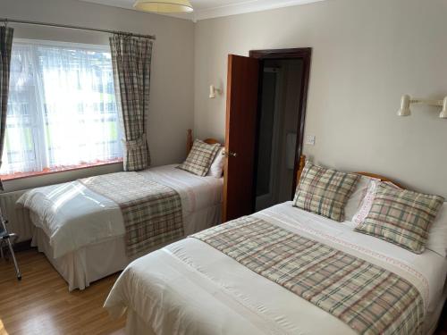 a bedroom with two beds and a window at Cois Farraige in Lahinch