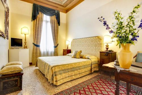 pokój hotelowy z łóżkiem i oknem w obiekcie Palazzo Schiavoni Residenza d'epoca & Suite-Apartments w Wenecji