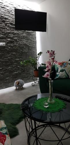 a living room with a table and a cat and a brick wall at Sylwia Aparthouse - Biały Dunajec in Biały Dunajec