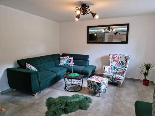 a living room with a green couch and two chairs at Sylwia Aparthouse - Biały Dunajec in Biały Dunajec