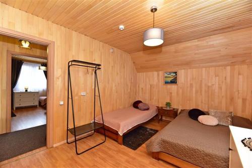 a room with two beds in a wood paneled room at Sodyba Sauletekis in Ignalina