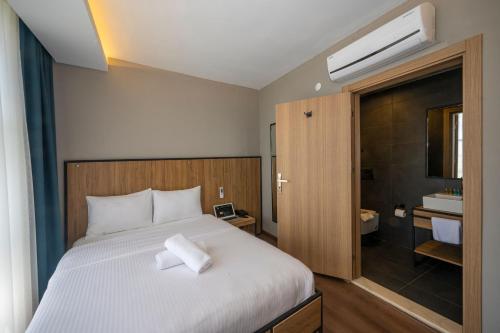 a bedroom with a white bed and a bathroom at Çorlu Dem Hotel in Çorlu