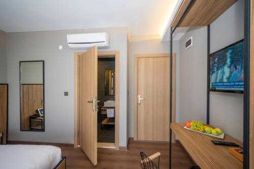 a bedroom with a bed and a desk with a television at Çorlu Dem Hotel in Corlu