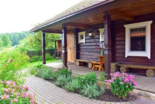 a wooden cabin with a bench on a patio at Sodyba Sauletekis in Ignalina