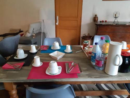 una mesa con platos y servilletas encima en ferme des champs, en Vrécourt