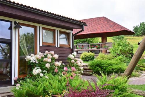 a small house with flowers in front of it at Sodyba Sauletekis in Ignalina