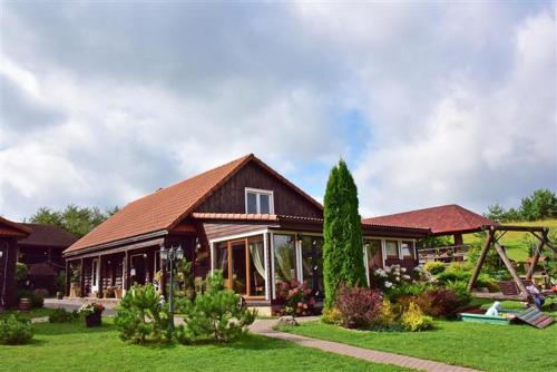 a house in a yard with a green lawn at Sodyba Sauletekis in Ignalina