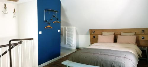 - une chambre avec un lit et un mur bleu dans l'établissement La Croix au Maitre, à Coulanges-la-Vineuse