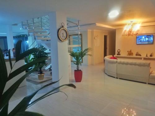 a lobby with a clock on a wall and a couch at Pousada Cavalero in Penha