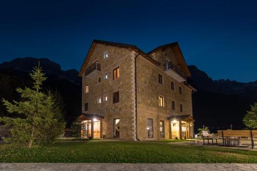 an old stone building at night with mountains at Hotel Margjeka in Valbonë