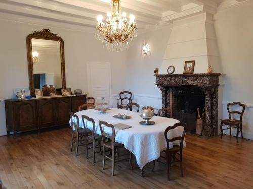 - une salle à manger avec une table, des chaises et un miroir dans l'établissement Manoir D Avray BEAUJOLAIS, à Saint-Just-dʼAvray