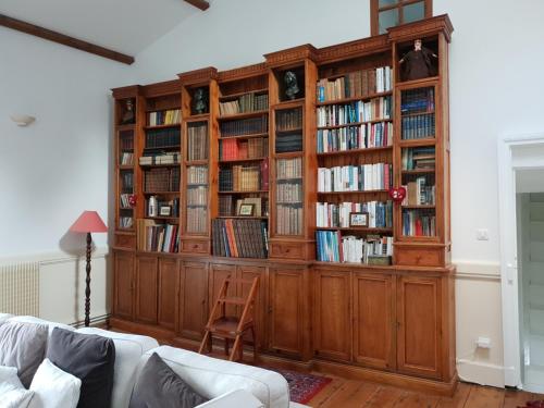 une grande étagère en bois remplie de livres dans l'établissement Manoir D Avray BEAUJOLAIS, à Saint-Just-dʼAvray